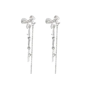 Silver bow dangle earrings with long wavy tassels and sparkling cubic zirconia stones