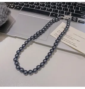 Dettaglio collana di perle grigio scuro con chiusura a moschettone argento e catena