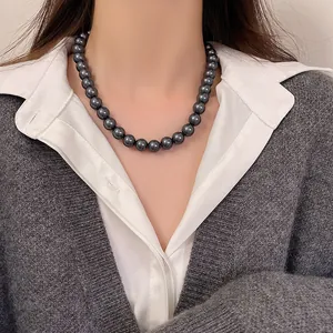 Collana di perle grigio scuro vintage francese indossata da una modella in stile chic