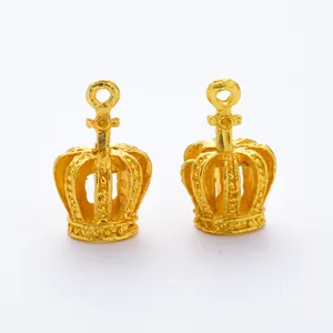 Detailed macro view of two hollow gold crown charms with embossed dots for DIY jewelry making