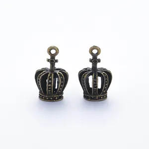 Macro detail of antique bronze hollow crown pendants with intricate floral relief textures