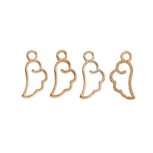 Detail of four golden alloy wing charms with hollow design for DIY jewelry making