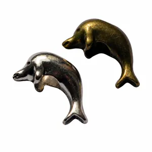 Makro-Detail von Delfin-Anhängern in Silber und Bronze für DIY-Armbänder Zubehör