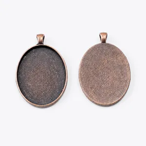 Macro detail of oval bronze alloy pendant trays with textured base for DIY jewelry making