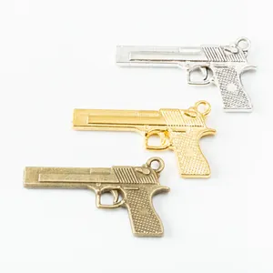 Set of 3 vintage alloy pistol charms in silver, gold, and bronze for DIY jewelry making