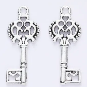 Pair of antique silver alloy key charms with intricate openwork patterns for DIY jewelry