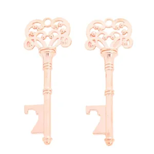 Detail of two rose gold vintage key bottle openers with ornate scrollwork on white background