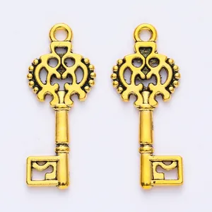 Detailed macro of golden alloy vintage key pendants with ornate hollowed patterns