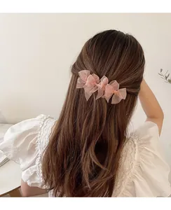 Dettaglio fermaglio per capelli con fiocchi in rete rosa su acconciatura semiraccolta