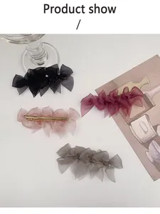 Dettaglio di quattro fermagli per capelli con fiocchi in tulle e clip in metallo oro