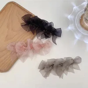 Eleganti fermagli per capelli con fiocco in tulle nero, rosa e grigio su vassoio