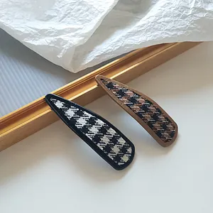 Set of two houndstooth fabric snap hair clips in black and brown minimalist style