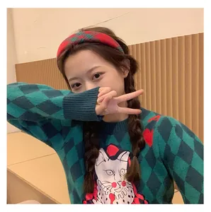 Detail of red and green plaid headband on a model wearing a vintage knit sweater