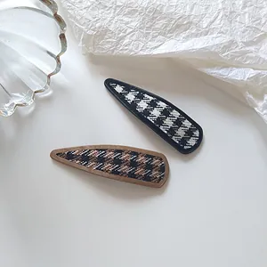 Detail view of two houndstooth patterns in black-white and brown-black on hair clips