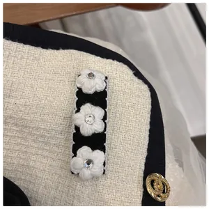 Detail of tweed hair clip with white camellia flowers and vintage gold button