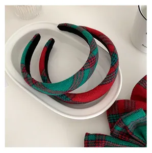 Detail of red and green plaid headband and matching scrunchie in a white ceramic tray