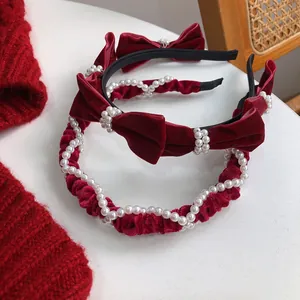 Detail of red velvet bow headband and ruched pearl hairband set with elegant texture