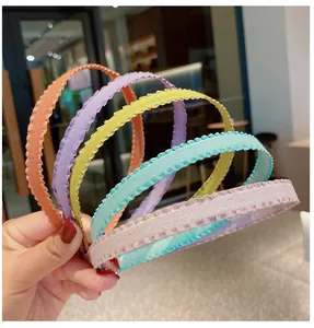 Close-up of five colorful pleated fabric headbands in candy tones for women