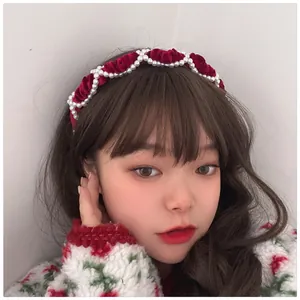 Detail of red velvet headband with pearl wave pattern decoration on model