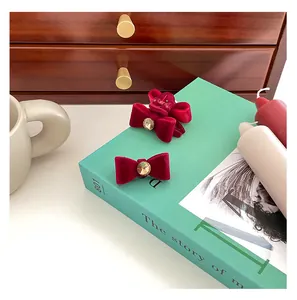 Detail of red velvet bow hair clips with crystal rhinestones on a decorative book