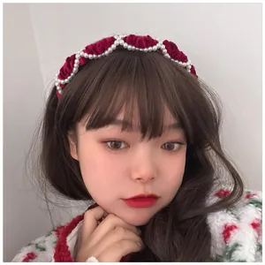 Detail of red velvet headband with pearls and wavy design on a female model