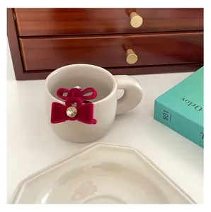 Close-up of red velvet bow hair clips with crystal center on a ceramic cup