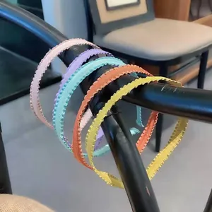 Pleated fabric headbands in assorted candy colors displayed on a black wooden chair