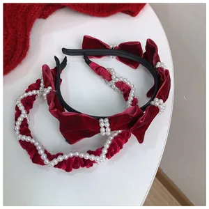 Detail of red velvet headband set with elegant pearls and festive bow accents