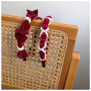 Detail of red velvet headbands with pearls featuring bow and twisted knot designs