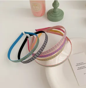 Détail de serre-têtes à carreaux aux couleurs acidulées et de fins bandeaux en tissu