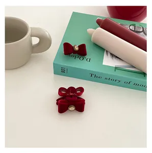 Detail of vintage velvet bow hair clips with crystal accents on a minimalist background