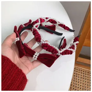 Detailed view of red velvet headbands featuring faux pearl accents and bow designs