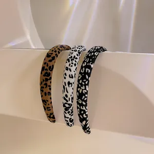 Three leopard print padded headbands displayed on an elegant white aesthetic stand
