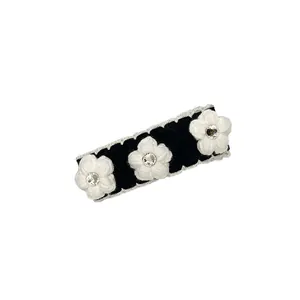 French style knitted camellia hair clip with black velvet base and sparkling rhinestones