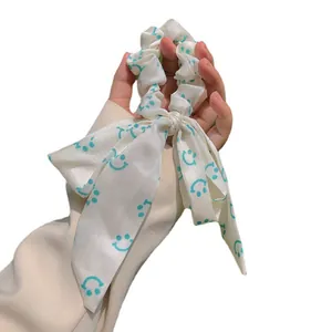 Chouchou en satin crème avec motifs smiley bleus et longs rubans à nœuds