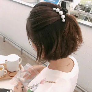 French style pearl hair claw clip worn on hair with large to small gradient white pearls