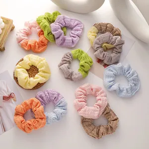Flat lay of colorful waffle knit hair scrunchies in pastel tones on white background