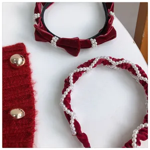 Close-up of wine red velvet headbands with delicate pearls and festive bow details