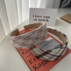 Detailed close-up of textured woven plaid headbands on an orange book in soft light