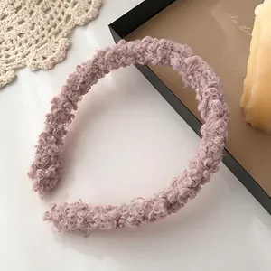 Close-up of pink purple sherpa fleece headband on a cozy vintage lace tabletop