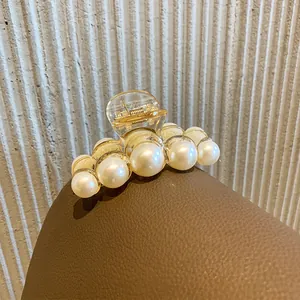 Elegant amber pearl hair claw clip with large beads on brown leather display stand