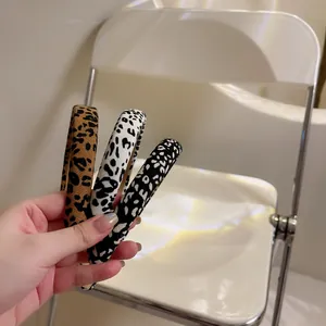 Close-up of three leopard print padded headbands in brown, cream, and grey fabric