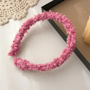 Detailed close-up of pink boucle fleece headband with textured soft plush fabric