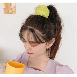 Close-up of lime green knitted scrunchie showing soft texture and high elasticity