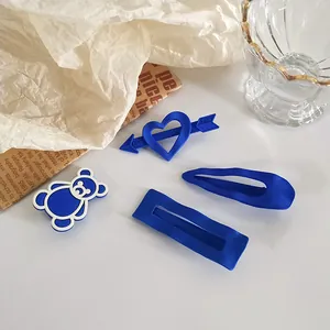 Set de quatre barrettes bleu Klein en formes d'ours, cœur, rectangle et goutte
