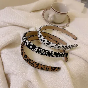Detailed view of three leopard print sponge headbands with non-slip lining on soft texture