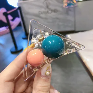 Detail of transparent triangle hair claw with colorful acrylic beads and metal spring