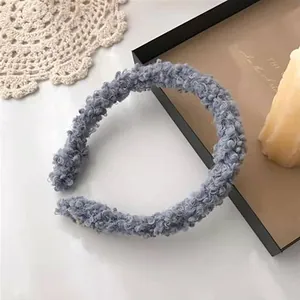 Close-up of fuzzy lamb wool headband in dusty blue with soft curly plush texture