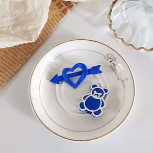 Set de barrettes bleu Klein mat avec cœur et ours sur une assiette en céramique