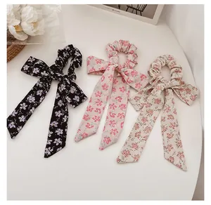Detailed view of floral scrunchies with long ribbons in assorted spring colors